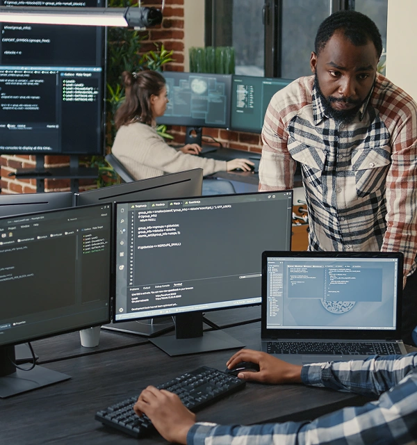 Person coding on multiple screens